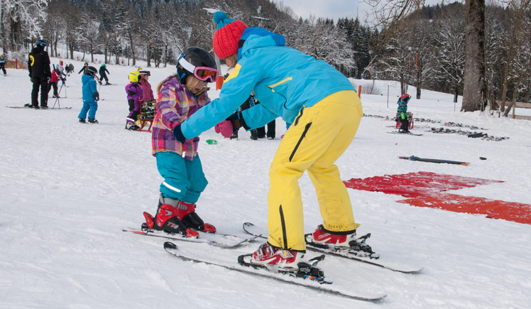 Skilehrerin kümmert sich um Kind